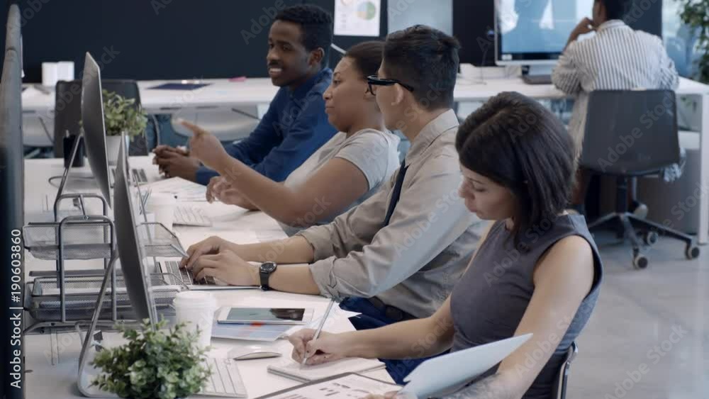 Poster multi-ethnic group of businessmen and businesswomen discussing something on computer screen while wo
