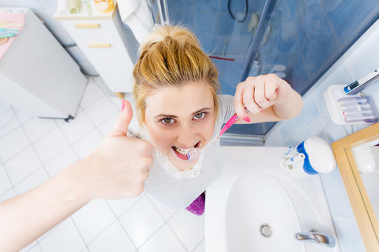 Woman brushing cleaning teeth in bathroom