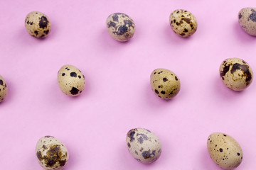 Holiday easter quail eggs on pastel purple background. Close up.