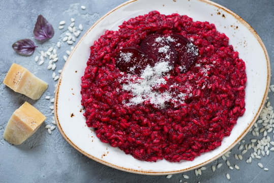Plate with beetroot risotto and parmesan cheese, view from above, studio shot