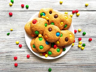 cookies made from cream cheese and colorful candies on a white wooden background with fading 