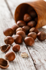 Hazelnut heap on wooden table, selective focus.