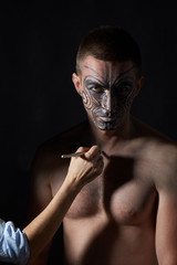 Portrait of a man with a tattoo on his face in the style of a Maori.