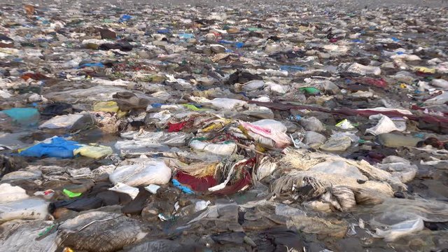 Zoom out view of plastic garbage and other pollution at Versova Beach in Mumbai, India 