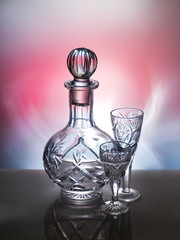 Crystal decanter and glasses on a red background 