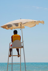 Lifeguard on duty in a toursim resort in the Mediterranean and blue sky and sea in the background