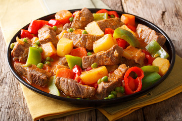 Beef filipino kaldereta with vegetables close-up on a plate on the table. horizontal