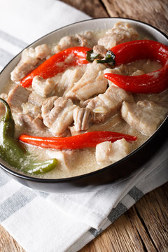 Filipino cuisine: stewed spicy pork in coconut milk with chili pepper. vertical