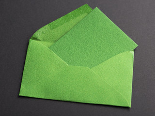 Letter green with a card inside on black background. Mockup.