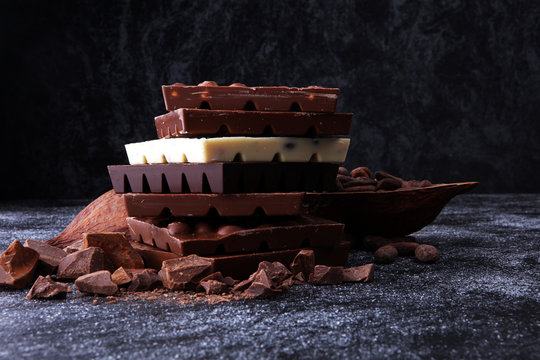 Chocolate bars on dark background with chocolate tower