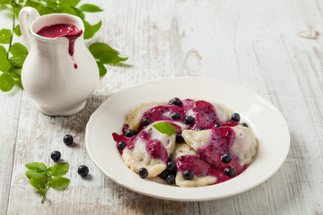 Delicious dumplings with fresh blueberries served with whipped cream and sugar or sauce.