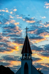 Obraz premium A silhouette of a church steeple in sunrise.