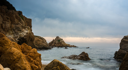 Sunset on a single beach full of rocks.