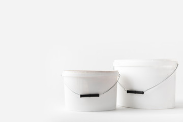 two plastic white buckets with paints isolated on white