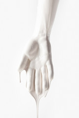 cropped image of female arm in white dripping paint isolated on white
