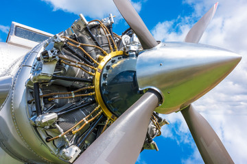 Close up view of airplane biplane with piston engine and propeller on a cloudy sky background © somchairakin