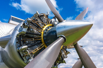 Close up view of airplane biplane with piston engine and propeller on a cloudy sky background