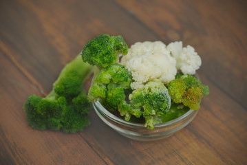 Brocoli and Cauliflower Vegetables Isolated in Glass bowl over Rustic Wooden Table. Top vieaw. diet and Healthy Food Concept.