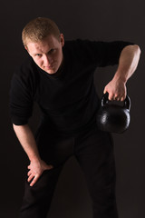 Man on a dark background lifting weights