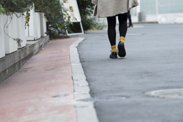 路地を歩く女性の足元