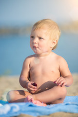 Baby playing with toys on the sandy beach near the sea. Cute little kid in  sand on tropical beach. Ocean coast.