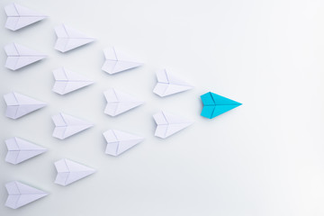 Leadership concept with blue paper plane leading among white.