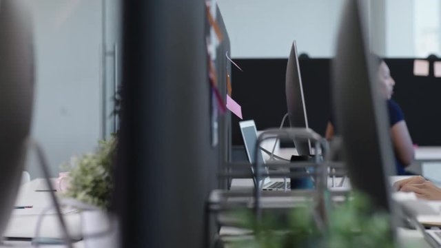 Tracking of company employees of diverse ethnicities leaving office and saying goodbye to young Asian colleague staying at work