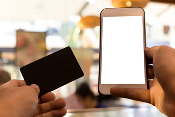 Hands holding credit card and using cell phone