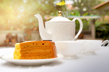 Afternoon tea with cup of tea and teapot and cake