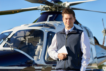 Portrait Of Pilot Standing In Front Of Helicopter With Digital Tablet © highwaystarz