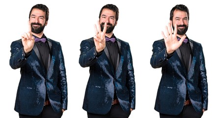 Handsome man with sequin jacket counting three, one and five