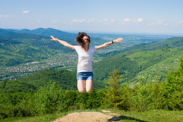 Young girl jumping on the mountains top