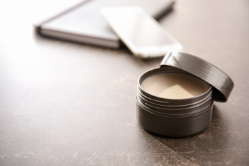 Jar with clay for hair on grey table