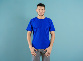 Young man in stylish t-shirt on color background. Mockup for design