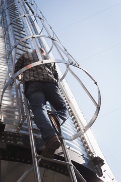 Man climbing ladder of grain elevator