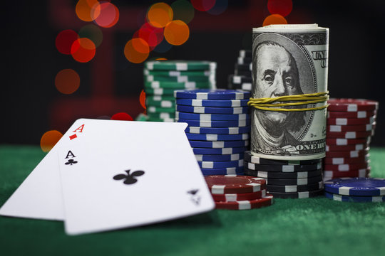 Poker chips, dollars and a pair of aces