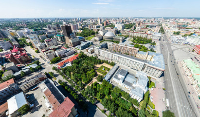 Aerial city view with crossroads, roads, houses, buildings, parks and parking lots. Copter drone helicopter shot. Panoramic wide angle image.