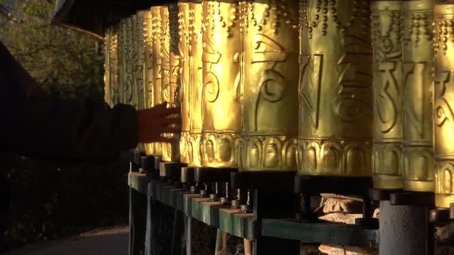 People spin Tibetan prayer wheels at Buddhist temple