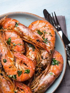 Grilled shrimps with parsley on pastel turqouise background. Shellfish dish