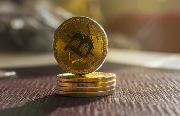 Stack of bitcoins with a single coin above. Photo of shining Bitcoins with golden sunrays. Digital decentralized currency.