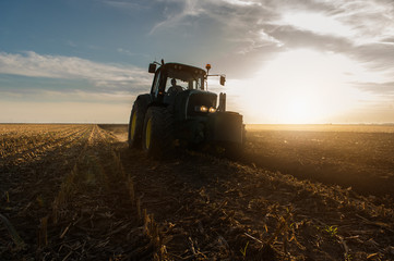 Fototapeta premium Tractor plowing fields -preparing land for sowing in autumn