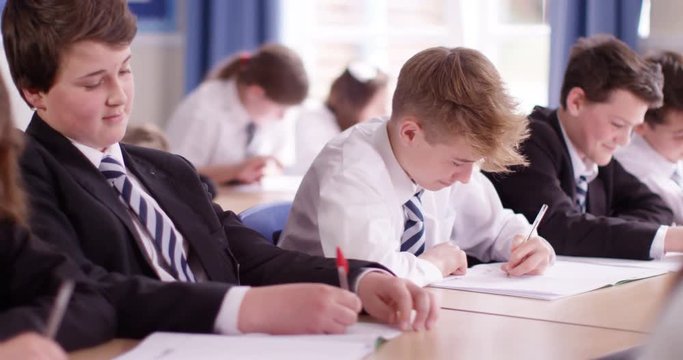 4k, Candid shot of school boys fighting playfully in a classroom. Slow motion.