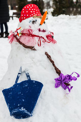 snowman with a red nose stands in the Park in the snow