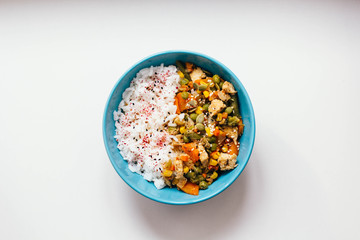 Rice with vegetables: carrots and corn, green beans, peas with pumpkin seeds and spices on white background. top view, close up, flat lay. vegetarian healthy or organic food concept.