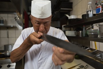 Senior chef holding knife in kitchen