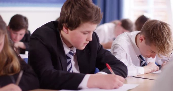 4k, Candid shot of school boys fighting playfully in a classroom. Slow motion.