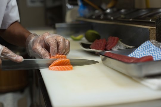 Chef preparing sushi in kitchen - Powered by Adobe