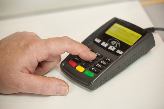 d&eacute;tail main tapant le code secret sur un terminal de carte bleue