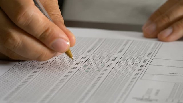 Close up on student hand filling multiple choice test