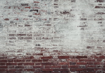 old brick wall of red and white brick, covered with plaster in some places covered with whitewash,...